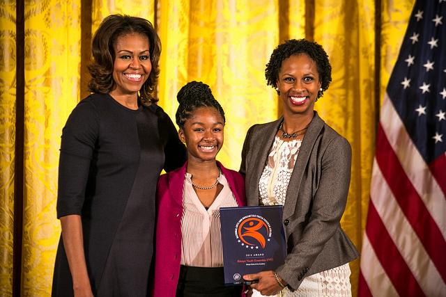 Ifetayo Youth Ensemble representatives Isoke Senghor (center) and Kwayera Archer-Cunningham (right) accept the 2013 National Arts and Humanities Youth Program Award from First Lady Michelle Obama. Photo credit: Ralph Alswang.